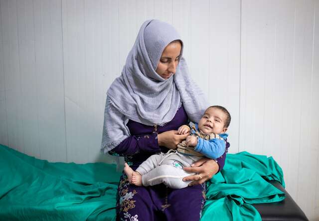 Eine Mutter hält ihr kleines Kind in den Armen in einer IRC-Klinik in Syrien.