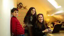 IRC client Zahra in her office with her children